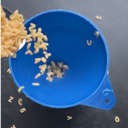 Das kreisrunde Foto zeigt einen blauen Trichter. In diesen werden Suppen-Buchstaben geschüttet.